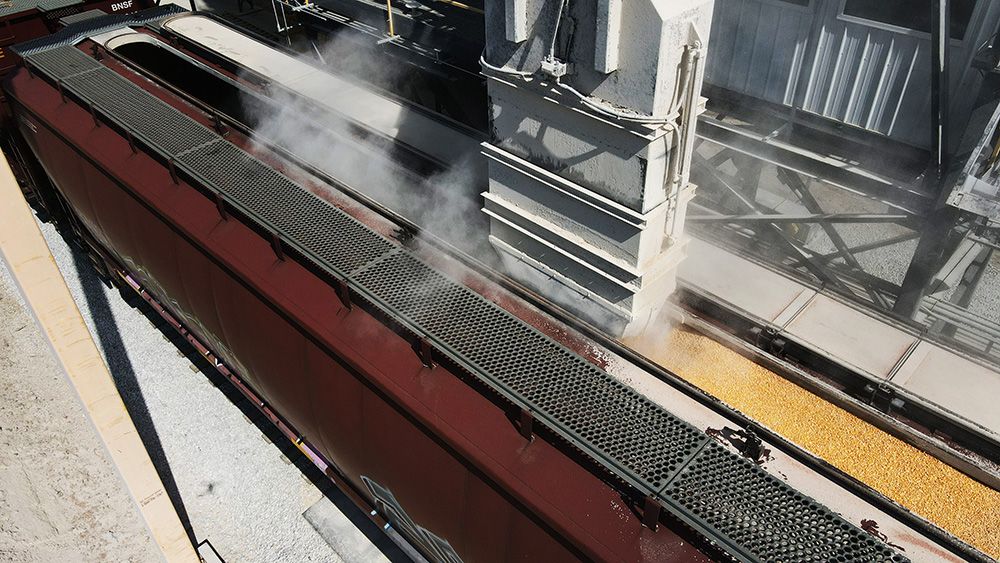 Grain loading into railcar at agricultural facility during bulk material transfer